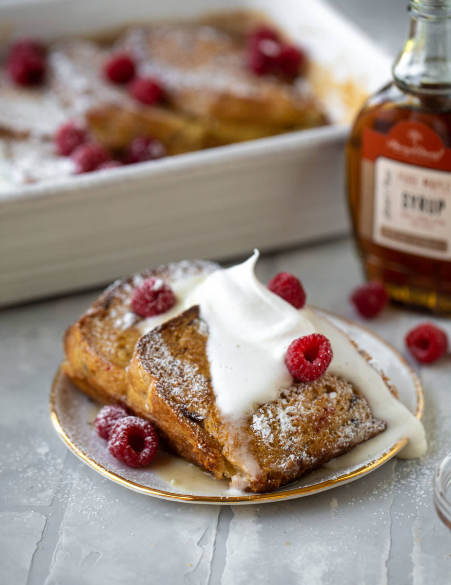French toast bake with whipped cream, berries, and maple syrup
