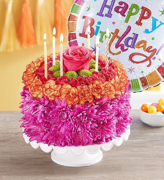 A photo of birthday gift ideas with a cake made out of flowers.